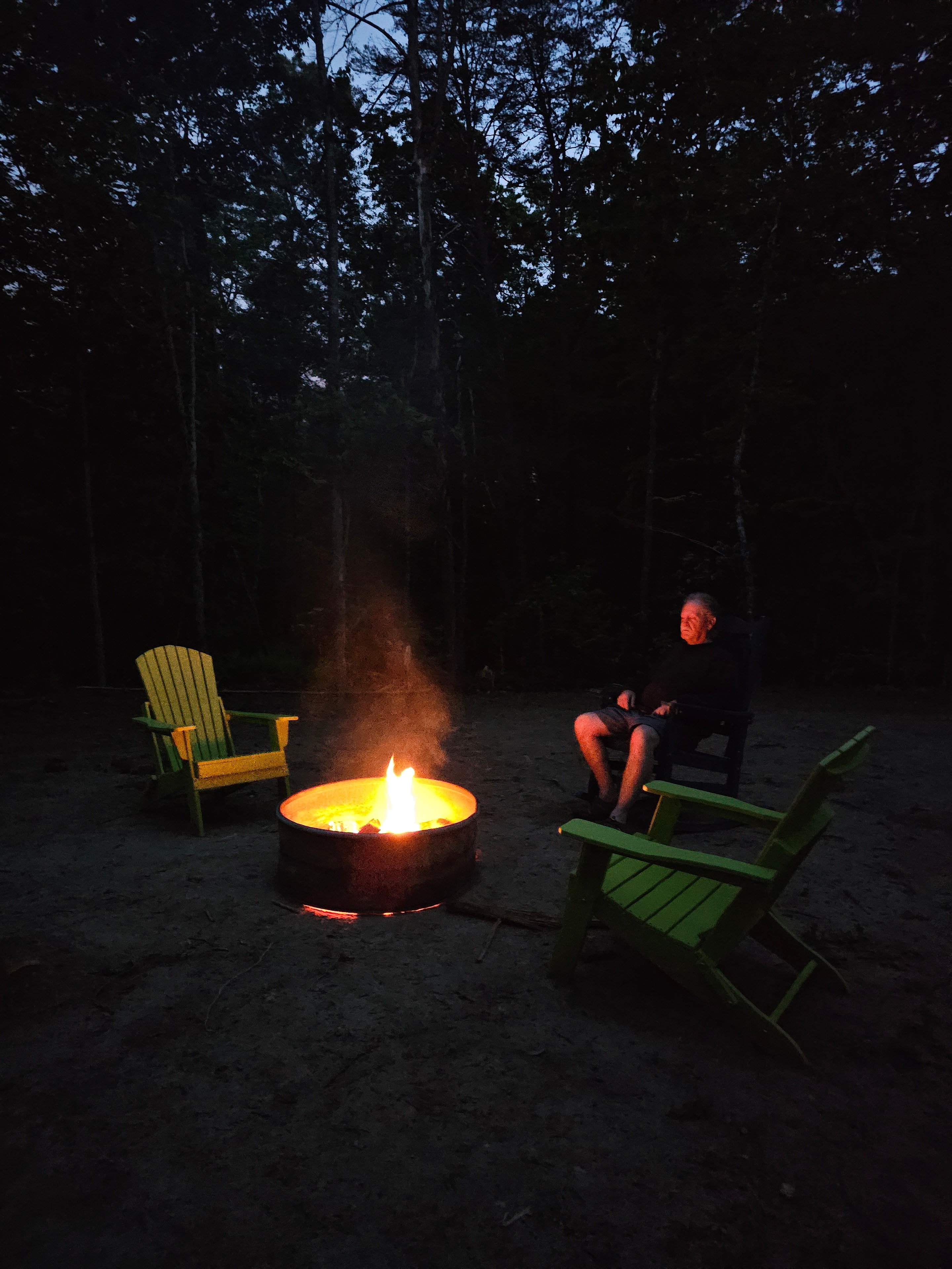 Shared fire pit at BLK147 with Adirondack chairs at night