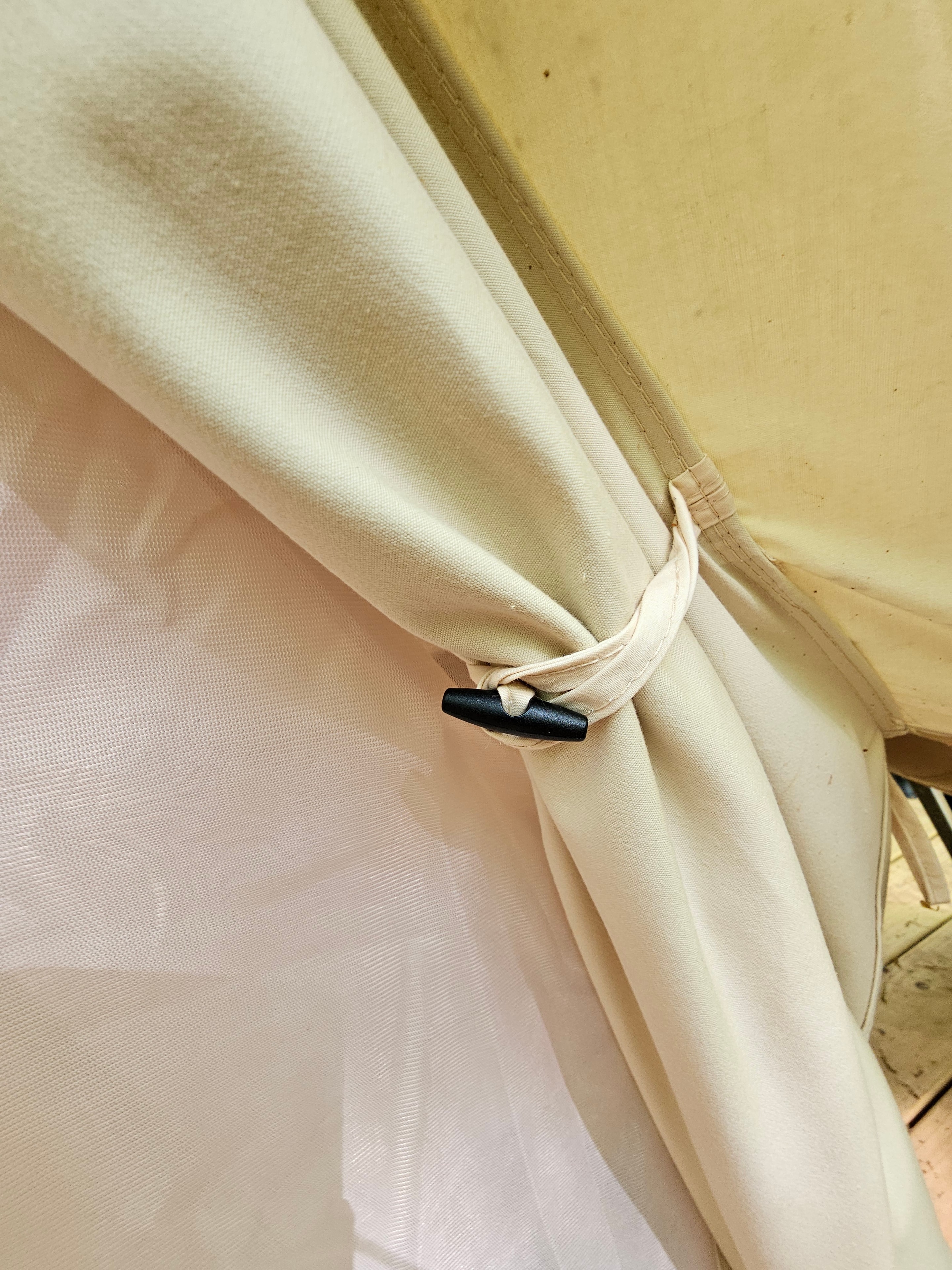 Cream curtains tied back at the tent door
